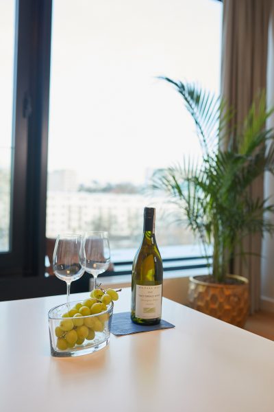 Wino, kieliszki i winogrona na stole przy oknie
