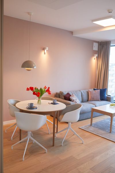 Okrągły stół jadalny z tulipanami i sofa w salonie