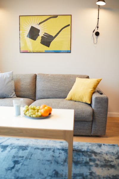 Sofa z żółtą poduszką i stolikiem kawowym w salonie