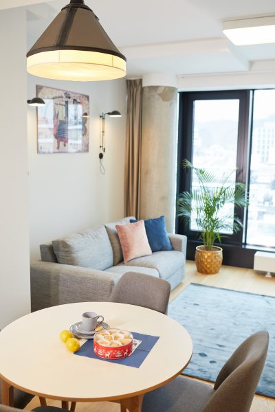Okrągły stół jadalny i sofa w salonie z widokiem na miasto